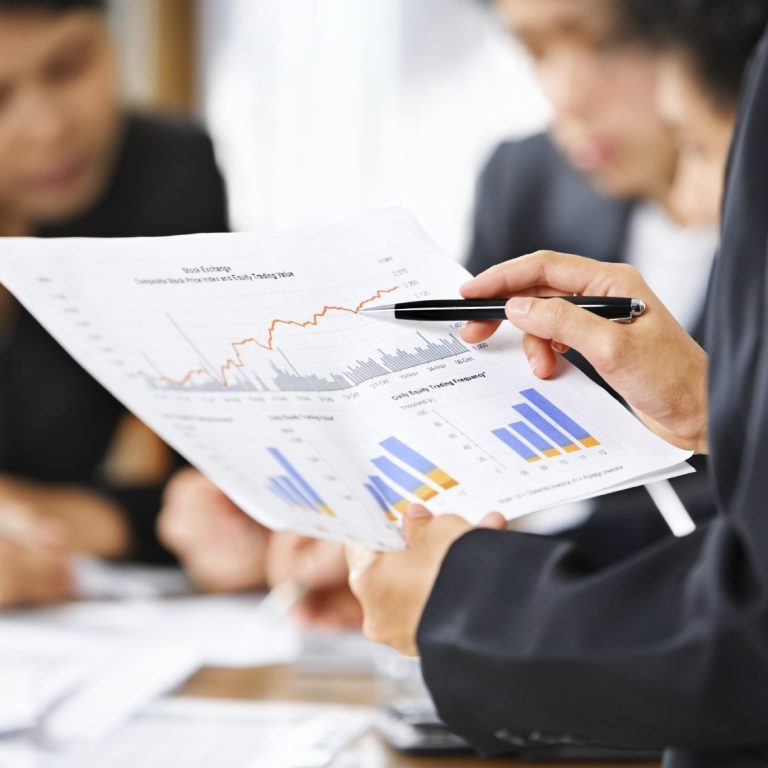 Group of people examining data charts at a table