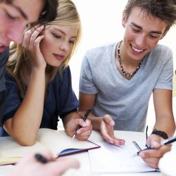 Three young adults sit planning at a table